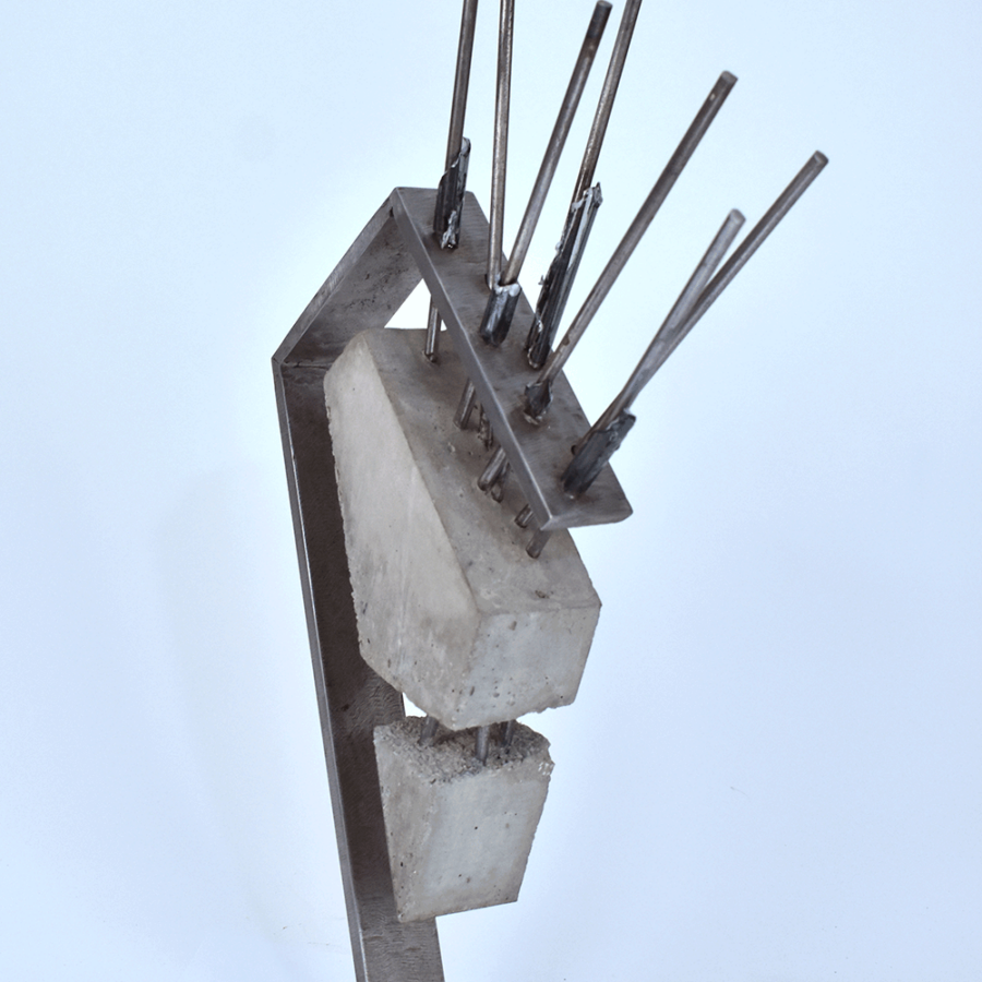 Abstract Sculpture of steel arm holding triangulated concrete block suspended by steel rods.